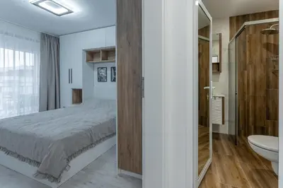 a bedroom with a bed and a bathroom with a sink at Bright and Cozy Apartment at a quiet Location in Sofia