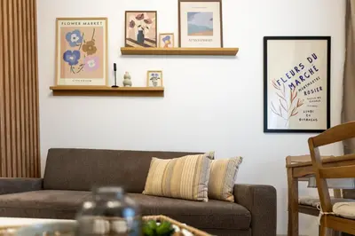 a living room with a couch and pictures on the wall at Bright and Cozy Apartment at a quiet Location in Sofia