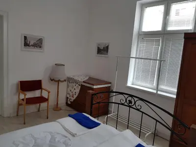 a bedroom with a bed and a chair and a window at Moder and Old Top in Sofia