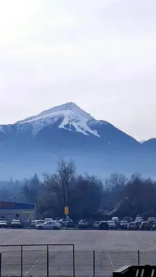 a snow covered mountain with cars parked in a parking lot at Steps from Gondola Private Underground Parking by SI Stay in Bansko