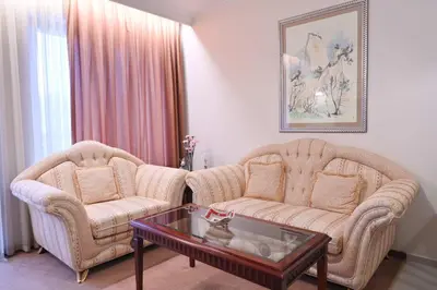 a living room with two chairs and a coffee table at Riverside 1BR in Downtown Near Ski Lift by Flat Mаnаger in Bansko