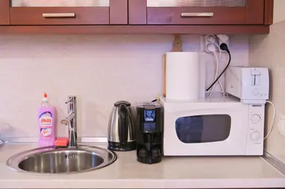 a kitchen counter with a sink and a microwave at Riverside 1BR in Downtown Near Ski Lift by Flat Mаnаger in Bansko