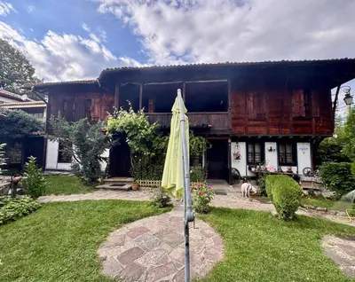 an umbrella in the yard of a house at Мандулова Къща in Koprivshtitsa