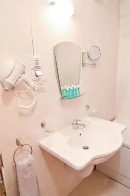 a white bathroom with a sink and a mirror at Aspen Resort Studio Cozy & Fully Equipped by Flat Manаger in Bansko