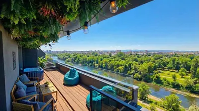 a balcony with a view of a river and trees at ApArt by the river in Plovdiv