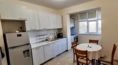 a kitchen with a table and a white refrigerator at violet's dream in Plovdiv