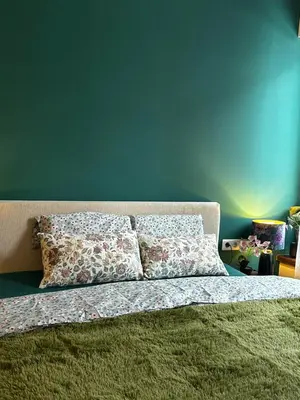 a bed with two pillows and a blue wall at Green Point Studio O12 in Chepelare