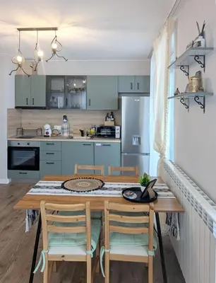 a kitchen with a wooden table with chairs and a refrigerator at Olive Urban Apartment, Free Parking in Sofia