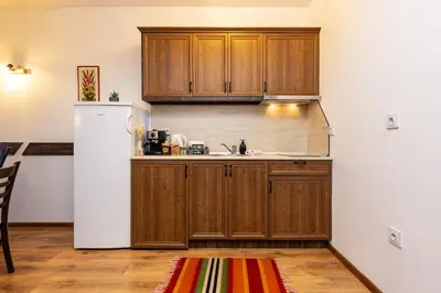 a kitchen with wooden cabinets and a white refrigerator at Vacation Home in Starosel Resort in Starosel