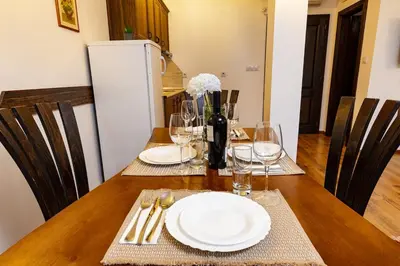 a wooden table with plates and wine glasses on it at Vacation Home in Starosel Resort in Starosel