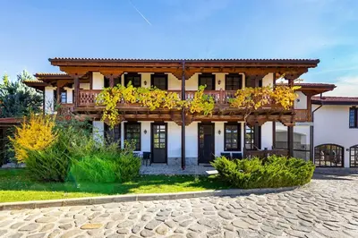 a large wooden house with a balcony at Vacation Home in Starosel Resort in Starosel