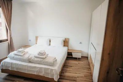 a bedroom with a white bed with towels on it at Къща за гости Бели Осъм in Beli Osŭm