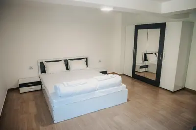 a bedroom with a large white bed and a mirror at Къща за гости Бели Осъм in Beli Osŭm