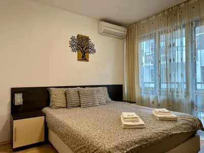 a bedroom with a bed and a large window at Ski Apartment Bansko Home2Host in Bansko