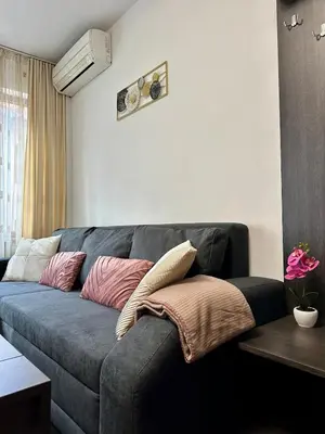 a couch with pillows on it in a living room at Ski Apartment Bansko Home2Host in Bansko