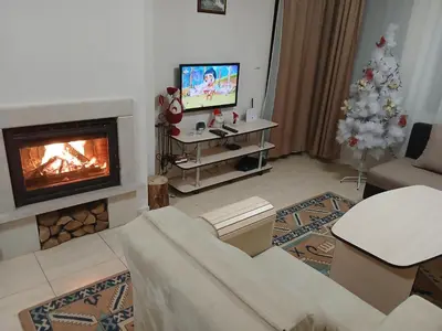 a living room with a fireplace and a christmas tree at Grand Monastery apt Emo Pamporovo in Smolyan