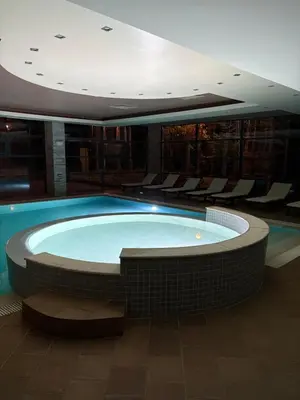 a large swimming pool in a building with chairs at Chamkoria Borovets luxury apartment view in Borovets