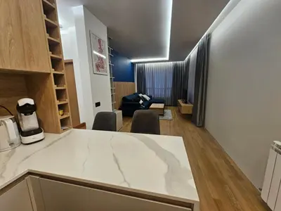 a kitchen and living room with a table and chairs at Luxury Forest Apartment in Borovets