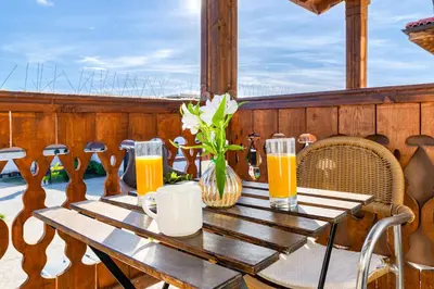 a wooden table with two glasses of orange juice at Vacation Apartment in Starosel complex in Starosel
