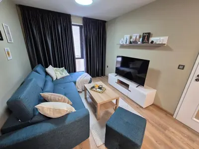 a living room with a blue couch and a television at SUPERsonicondo 4 in Plovdiv