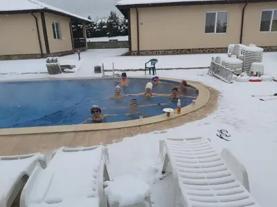 a group of people in a swimming pool in the snow at Вилен комплекс Дарибел in Sapareva Banya
