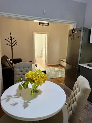 a kitchen with a white table with yellow flowers on it at Central Elegance NDK 3BDR in Sofia