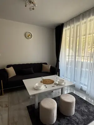 a living room with a table and a couch at Thermal Bliss Apartment in Velingrad