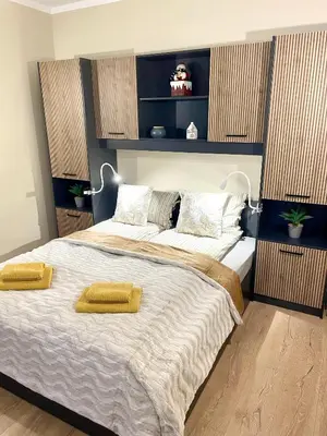 a bedroom with a large bed with two yellow pillows on it at 1BR Apartment Near Gondola by SI Stay in Bansko