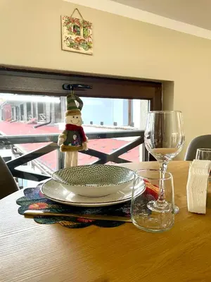 a table with a plate and a glass of wine at 1BR Apartment Near Gondola by SI Stay in Bansko