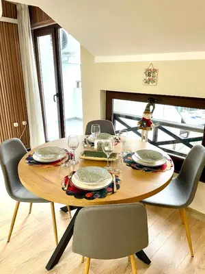a dining room table with chairs and a table with glasses at 1BR Apartment Near Gondola by SI Stay in Bansko
