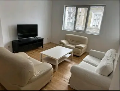 a living room with two couches and a tv at Апартамент 21 in Sofia