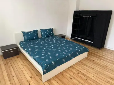 a bedroom with a bed with blue sheets and a tv at Апартамент 21 in Sofia