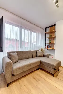 a living room with a brown couch in front of a window at Alpine Hideaway at The Castle in Smolyan