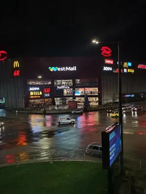 a night view of a parking lot in front of a store at West Park in Sofia