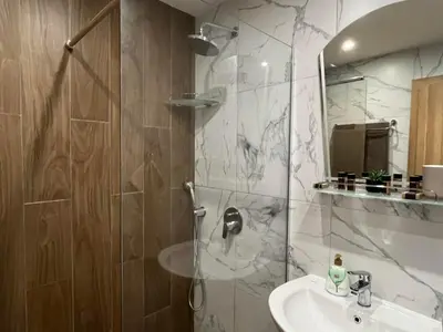 a bathroom with a shower and a sink and a mirror at RIA studio in Borovets Gardens hotel in Borovets
