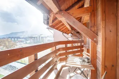 a wooden balcony with a bench and a view at 400m from Ski Belvedere Apartment - Free Parking - SPA in Bansko