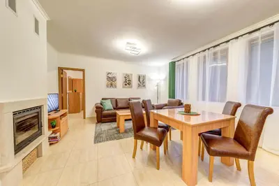 a living room with a table and chairs and a fireplace at Winter Heaven Grand Monastery Pamporovo in Pamporovo