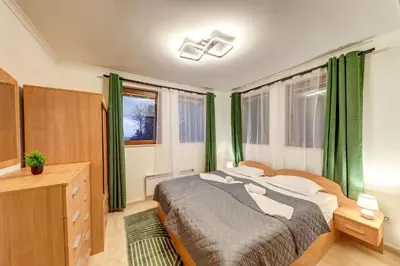 a bedroom with a large bed with green curtains at Winter Heaven Grand Monastery Pamporovo in Pamporovo