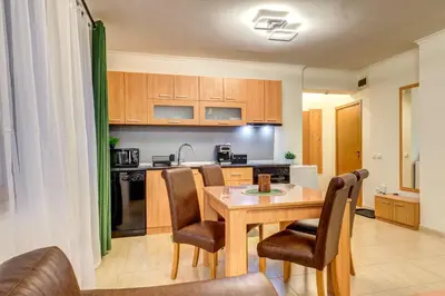 a kitchen with a wooden table and chairs and a kitchen with a sink at Winter Heaven Grand Monastery Pamporovo in Pamporovo