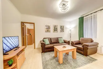 a living room with a couch and a tv and a table at Winter Heaven Grand Monastery Pamporovo in Pamporovo