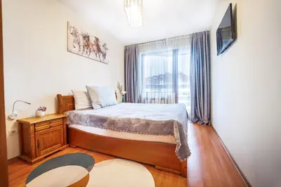 a bedroom with a bed and a large window at 400m from Ski lift Belvedere Apartment - SPA - Free parking in Bansko
