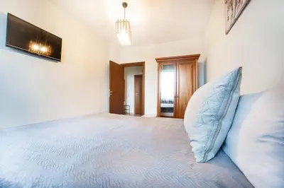 a bedroom with a large bed with a blue pillow at 400m from Ski lift Belvedere Apartment - SPA - Free parking in Bansko