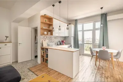 a kitchen and dining room with a table and a counter at Cozy 2BDR Balcony Apt with View in Historic Center in Sofia