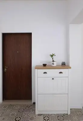 a white cabinet with a plant on top of it next to a door at Cozy 2BDR Balcony Apt with View in Historic Center in Sofia