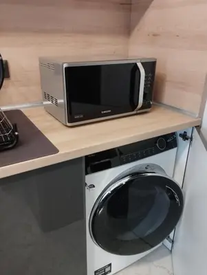 a microwave sitting on a counter next to a washing machine at Plovdiv Moon - 1 Bedroom Luxury Apartment in Plovdiv