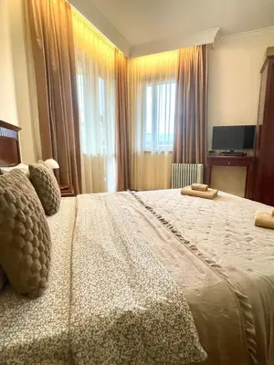a bedroom with a large bed with curtains and a television at Cozy 1BR next to the Gondola by SI Stay in Bansko
