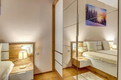 a small bedroom with a bed and a glass wall at Cozy Evrika 2 Mountain Home in Pamporovo