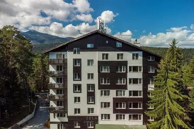 a large apartment building with a mountain in the background at Sunlit Forest Suite in Borovets