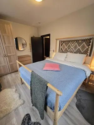 a bedroom with a large bed with a blue blanket at Tranquility Apartment Pirin Golf in Razlog