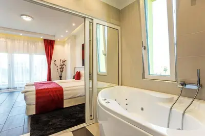 a bathroom with a bath tub and a bed at Complex Europe in Dolna Banya